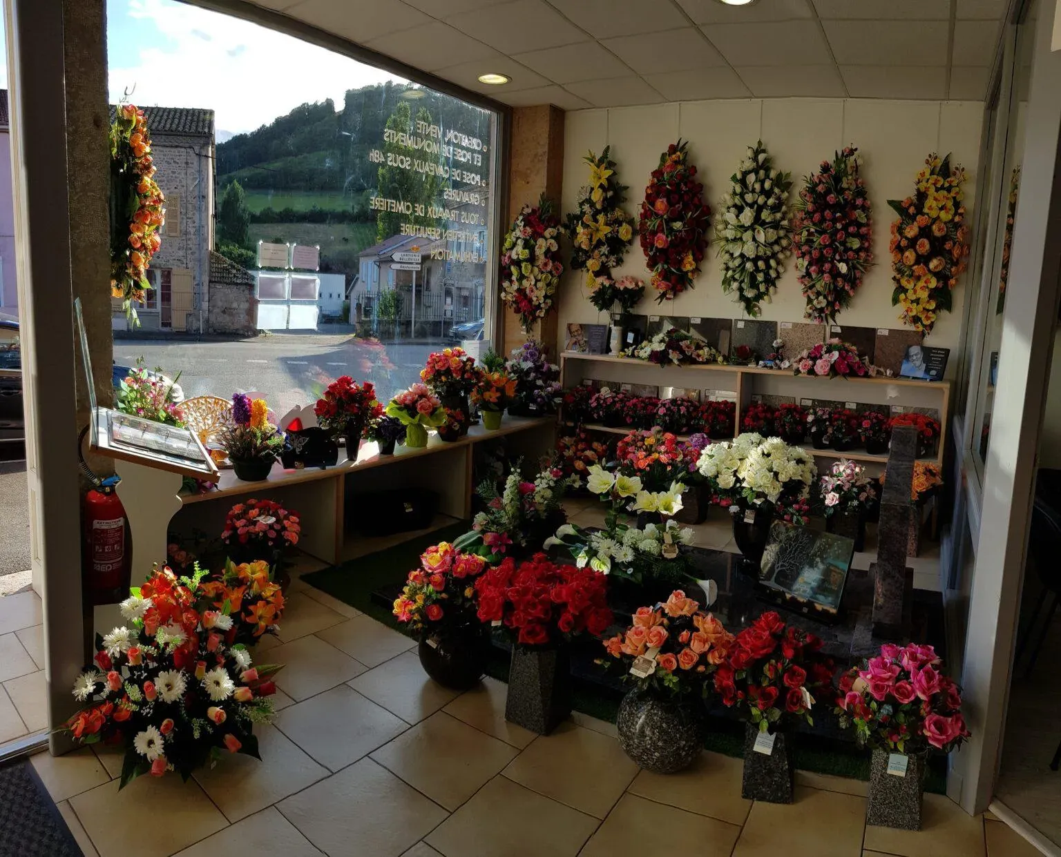 Intérieur de magasin de pompes funèbres présentant des compositions florales et articles funéraires