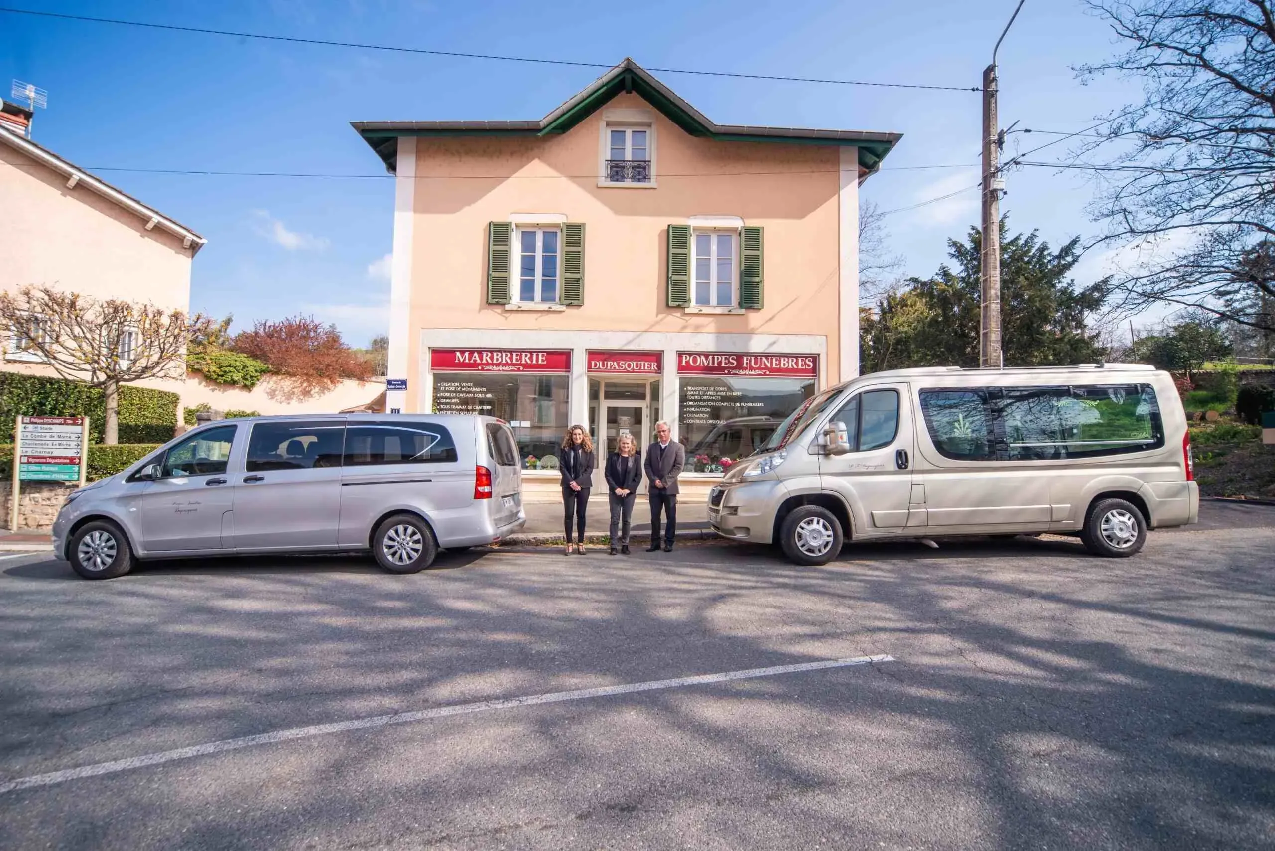 Devanture des pompes funèbres Dupasquier avec l'équipe et deux véhicules du convoi funéraire