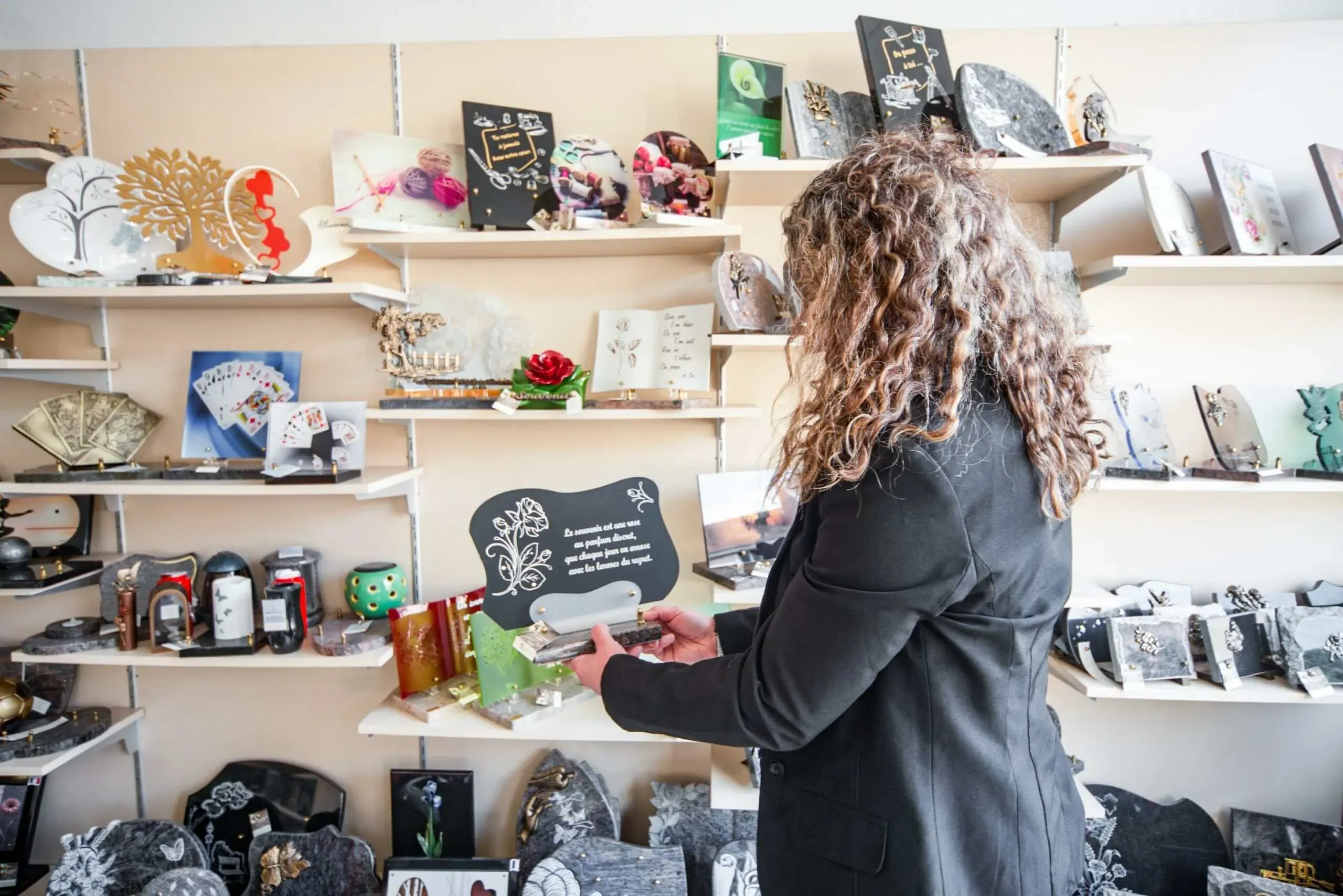 Femme choisissant une plaque funéraire commémorative personnalisée en magasin de marbrerie