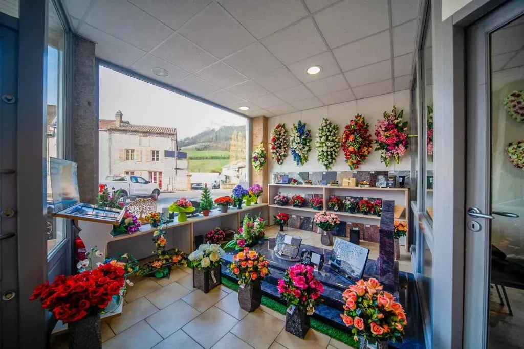 Intérieur de magasin de pompes funèbres présentant des compositions florales et articles funéraires
